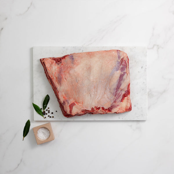 Silver Fern Farms Beef Whole Short Ribs top view on marble board with herbs, salt and pepper on side