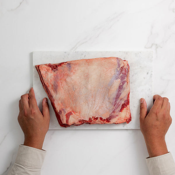Silver Fern Farms Beef Whole Short Ribs top view on marble board with hands holding the marble board