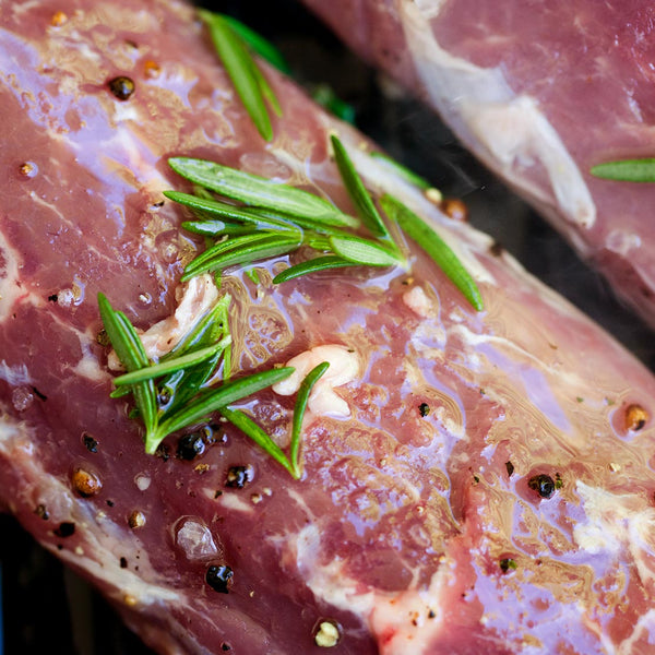 Raw lamb loin meat with rosemary, garlic pepper, salt, and oil for marinate